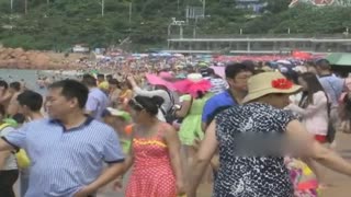 高温来袭实拍4万游客海水浴场“下饺子” 脸基尼大妈抢镜